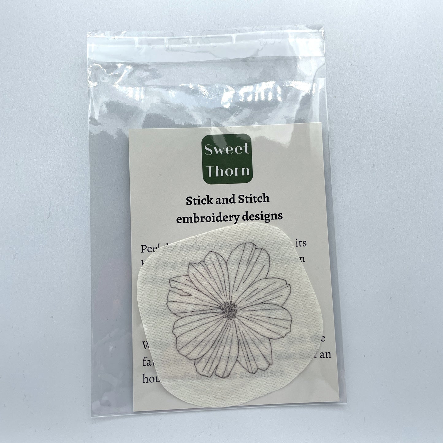 Cosmos flower head embroidery sticker in cellophane bag with instructions