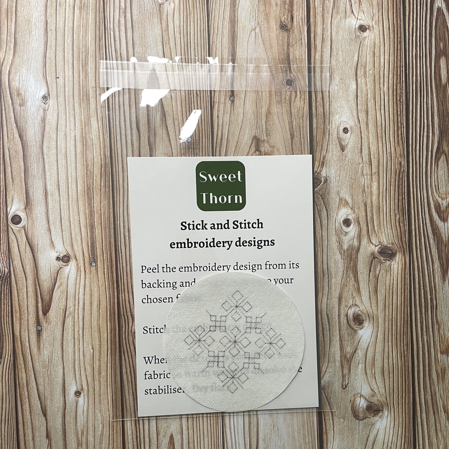 Embroidery sticker in cellophane bag with instructions.