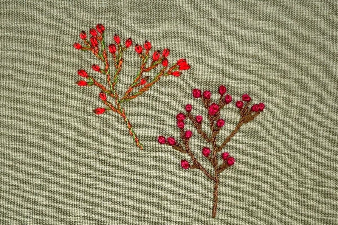Rose hips and hawthorn berries embroidered in lazy daisy stitch and French knots.