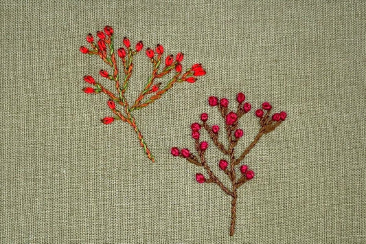 Rose hips and hawthorn berries embroidered in lazy daisy stitch and French knots.