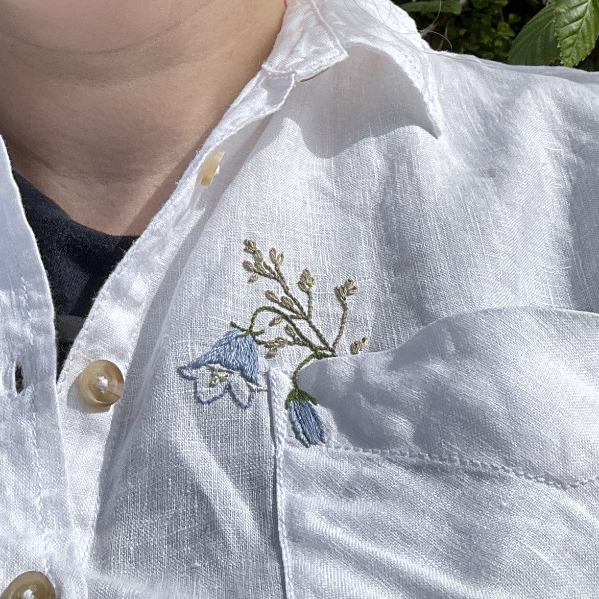 harebell and meadow grass posy embroidered in the pocket of a white linen shirt