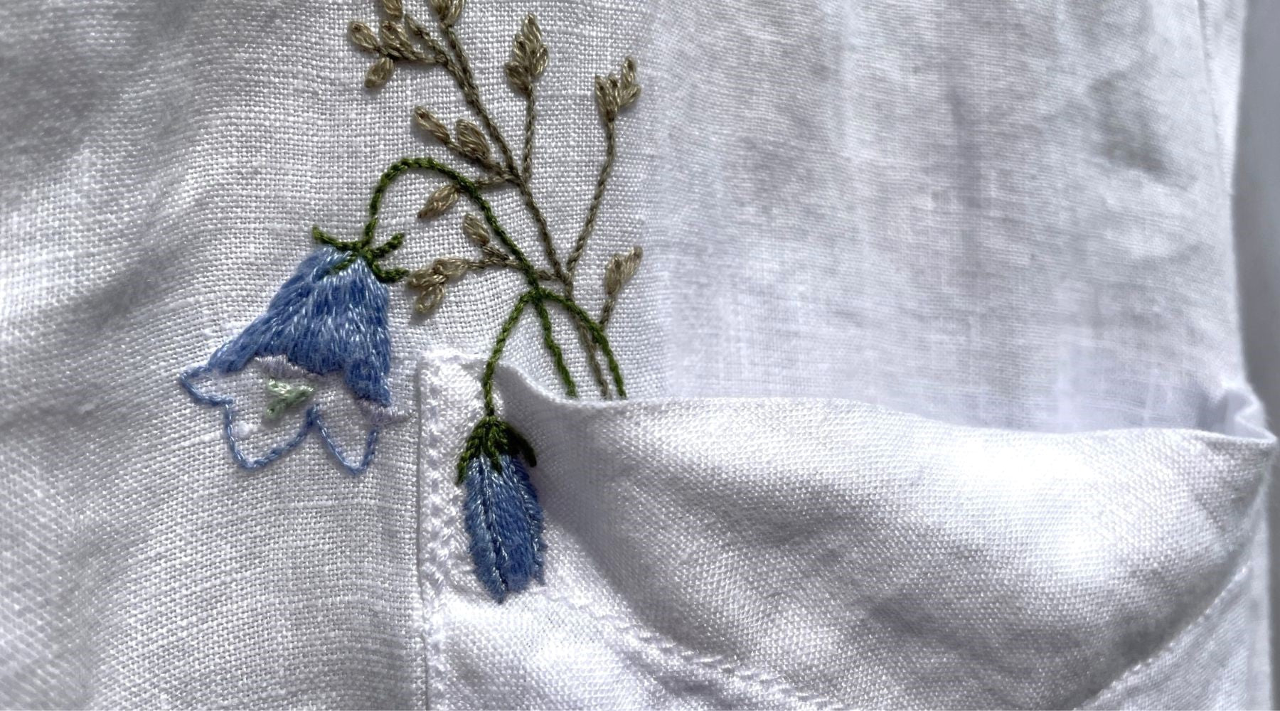 Embroidered harebells in a white linen shirt pocket